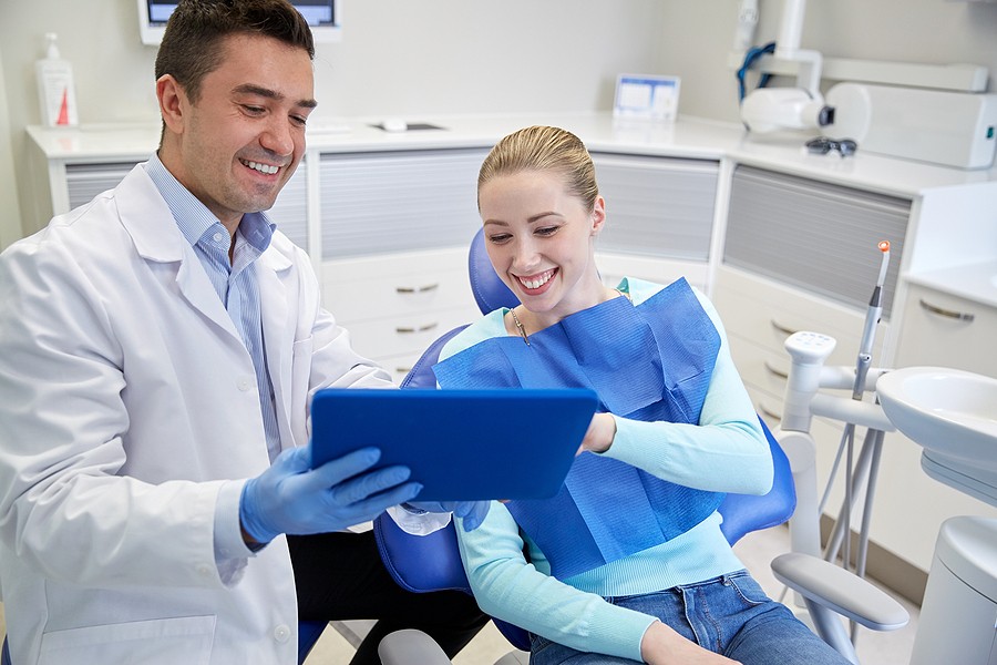 A woman at the dentist's office looking at results from getting an oral cancer screening.