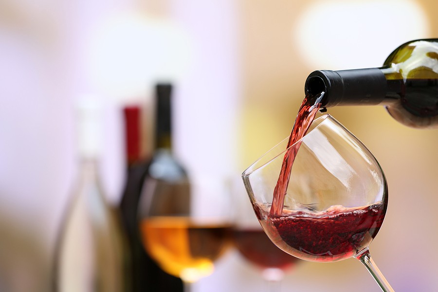 Pouring wine representing how does alcohol affect your teeth.