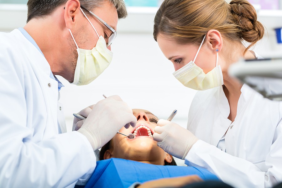 A dental team performing wisdom teeth removal on a patient, illustrating the procedure and professional dental care.