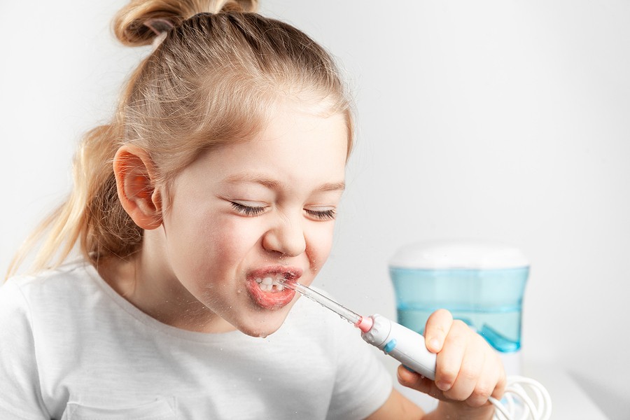 Child using a water flosser for daily oral hygiene