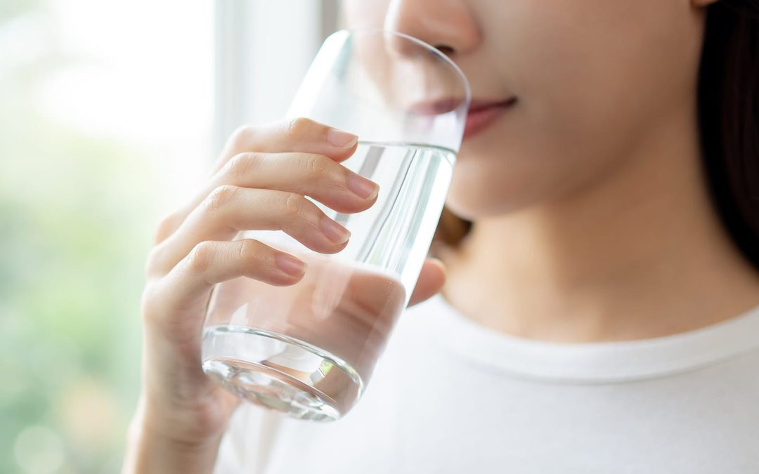 Woman drinking water to relieve chronic dry mouth symptoms